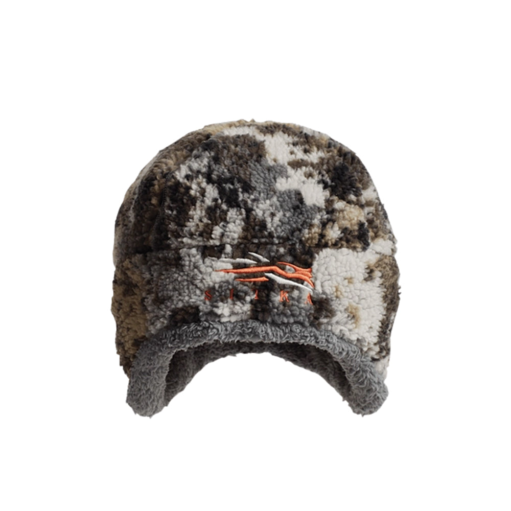 A camouflage-patterned fleece hat with ear flaps and orange embroidered Sitka logo on the front, shown against a plain white background.