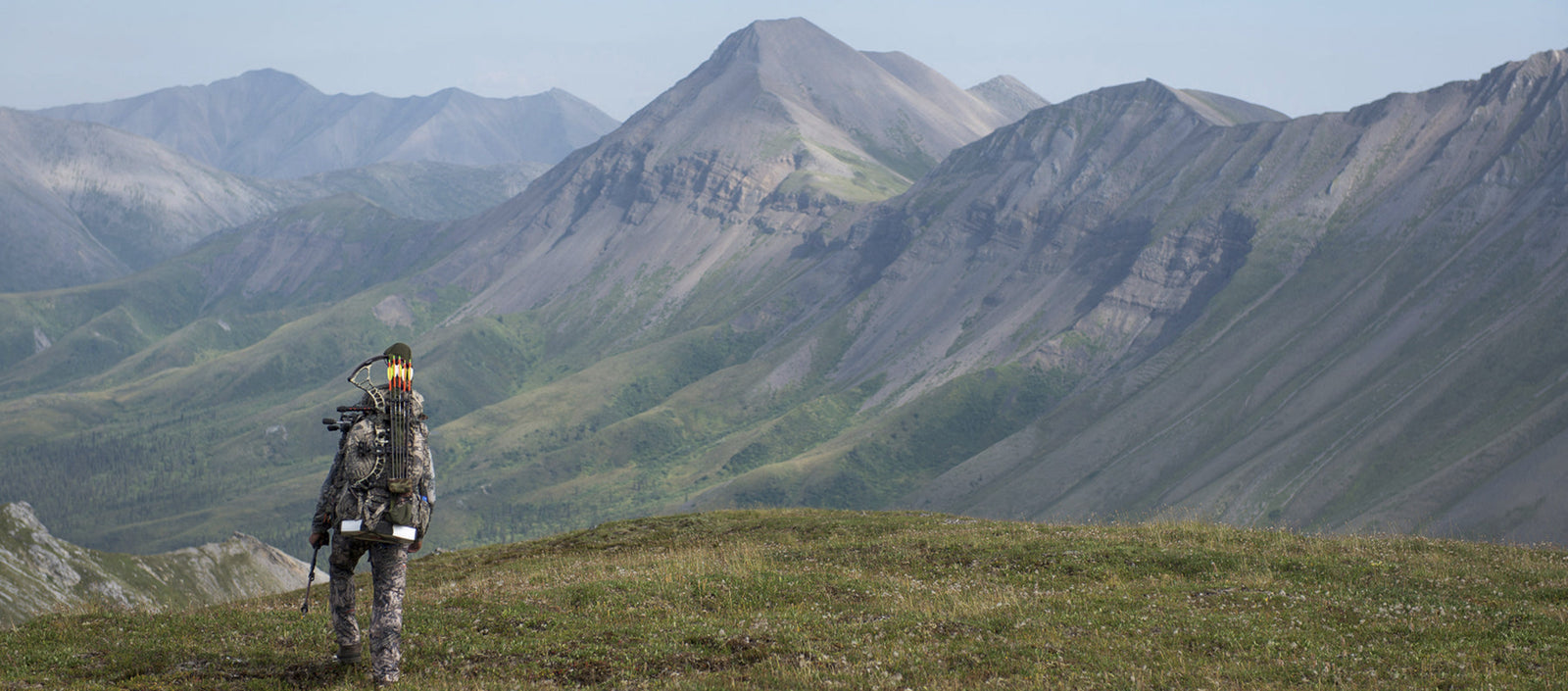 bowhunter hiking in mountains